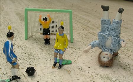 Alte Puppenstubenpuppe aus Porzellan mit Tipp-Kick-Fußballern aus den 70er Jahren
